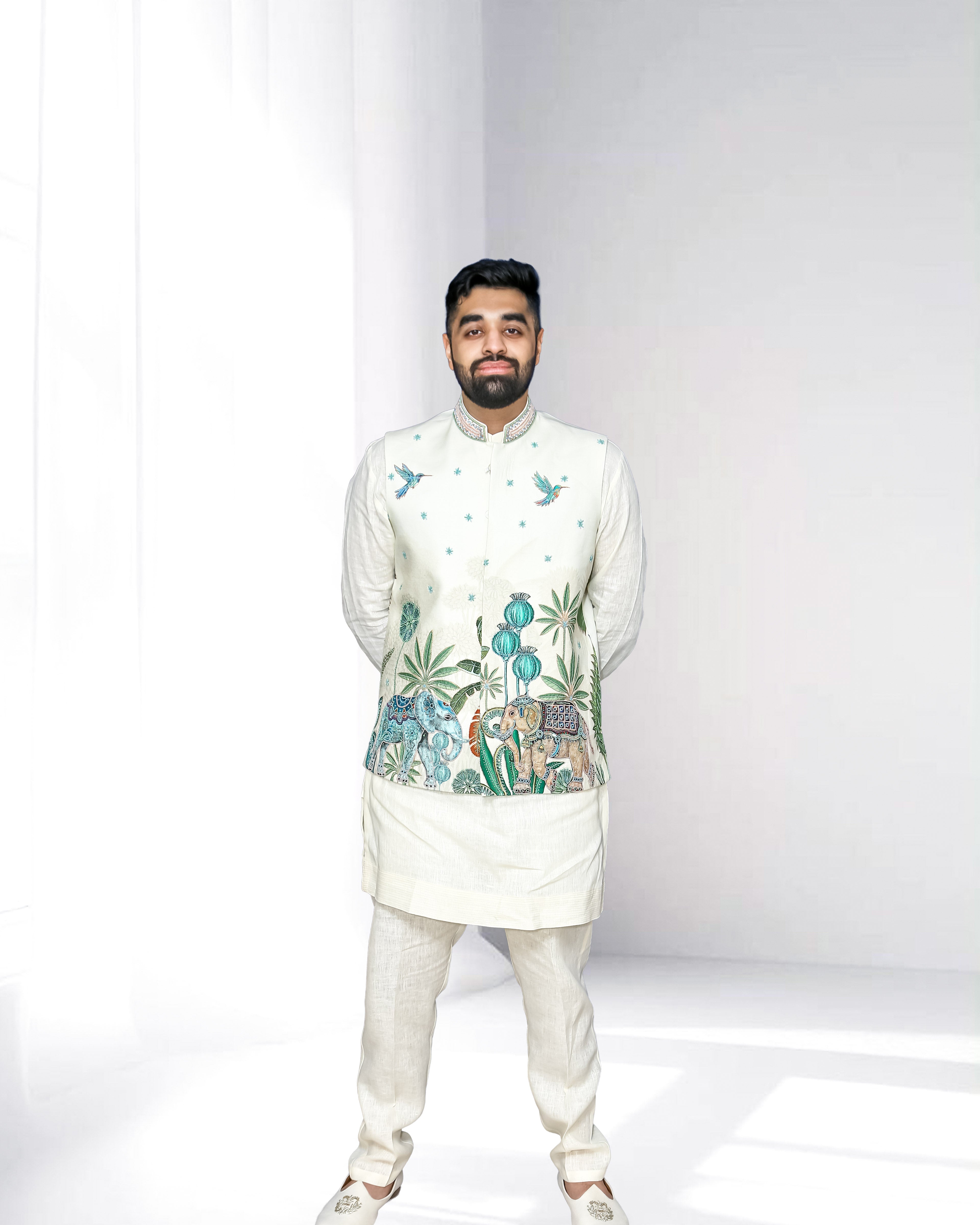 Man wearing a traditional embroidered Kurta Pajama with Nehru Jacket on a white background