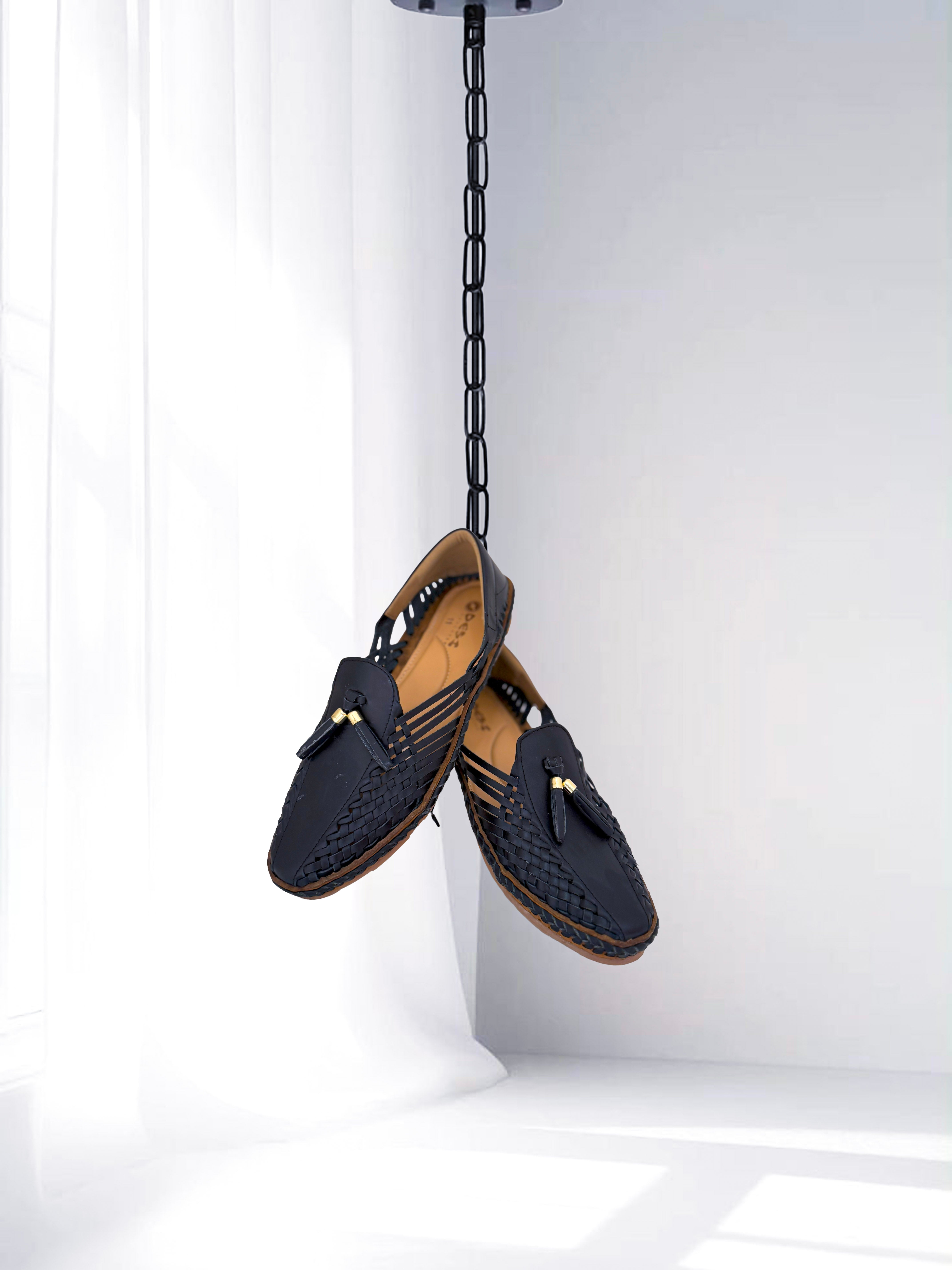 Black woven leather men’s loafers with tassel, stylish ethnic and casual footwear.