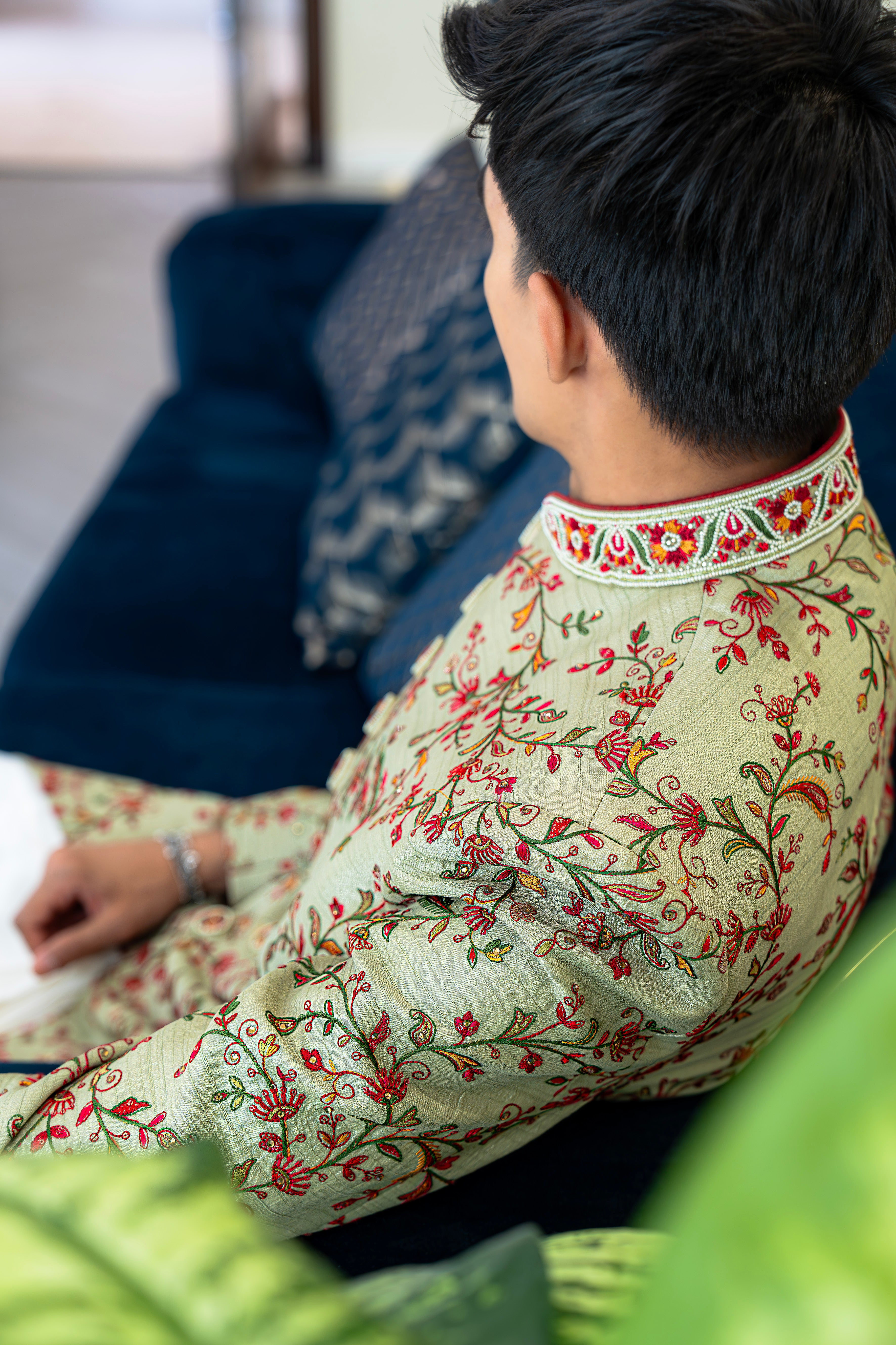 Person wearing a floral kurta sitting on a couch