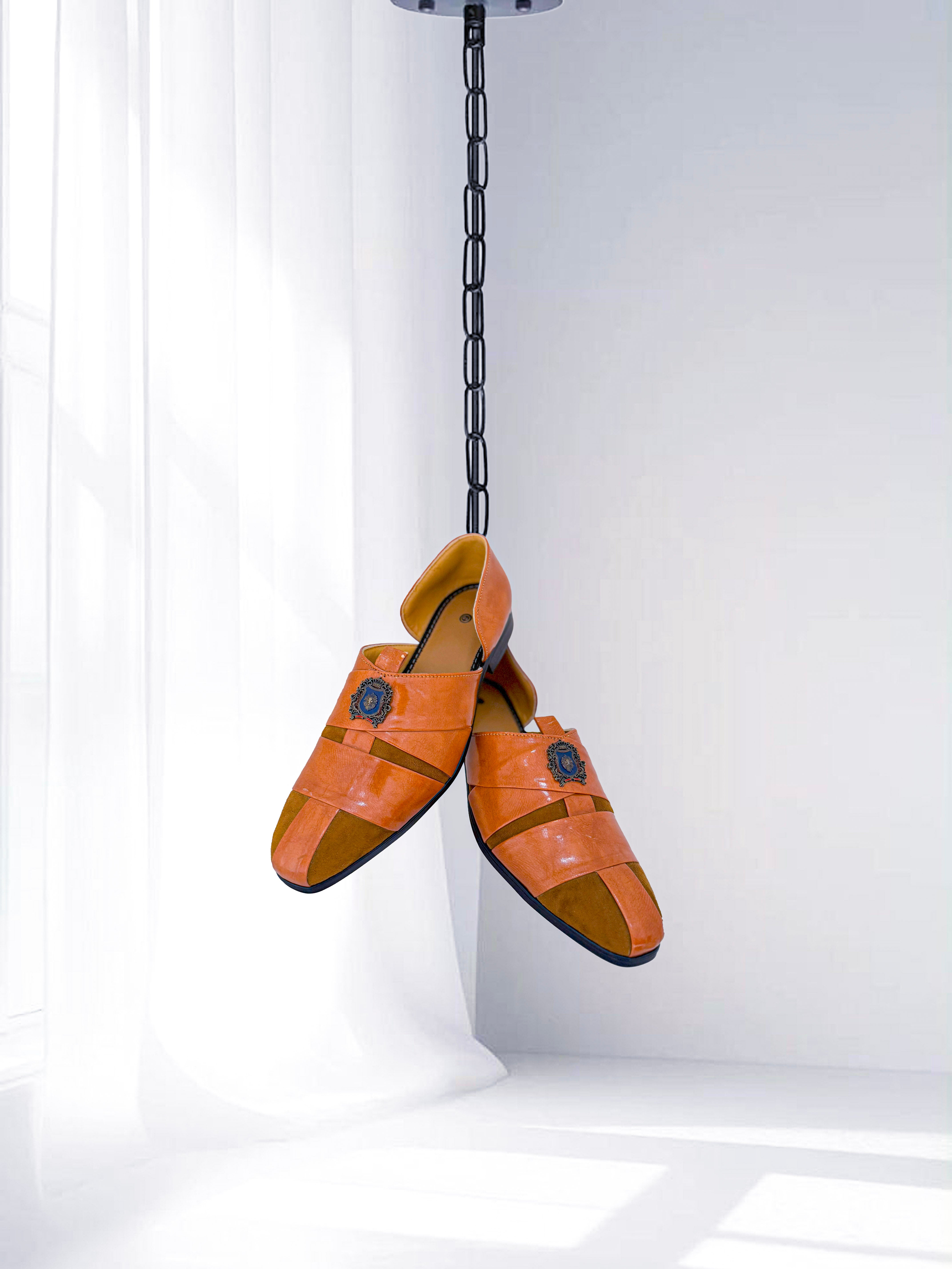 Orange leather Kolhapuri-style men’s sandals with emblem detail, ideal for ethnic wear and weddings.