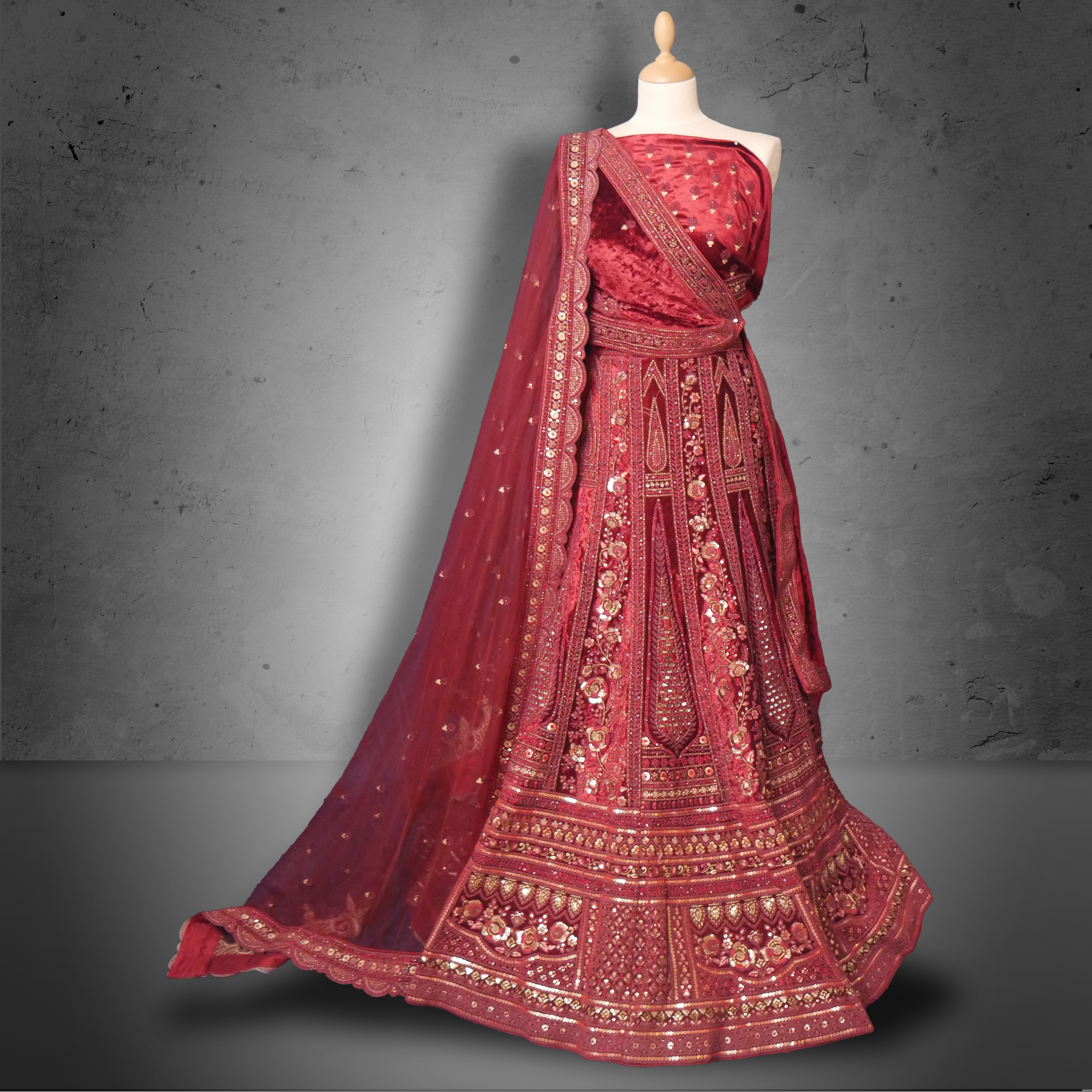 Unstitched red maroon velvet lehenga set with zari, mirror, and sequin embroidery, paired with a matching net dupatta.