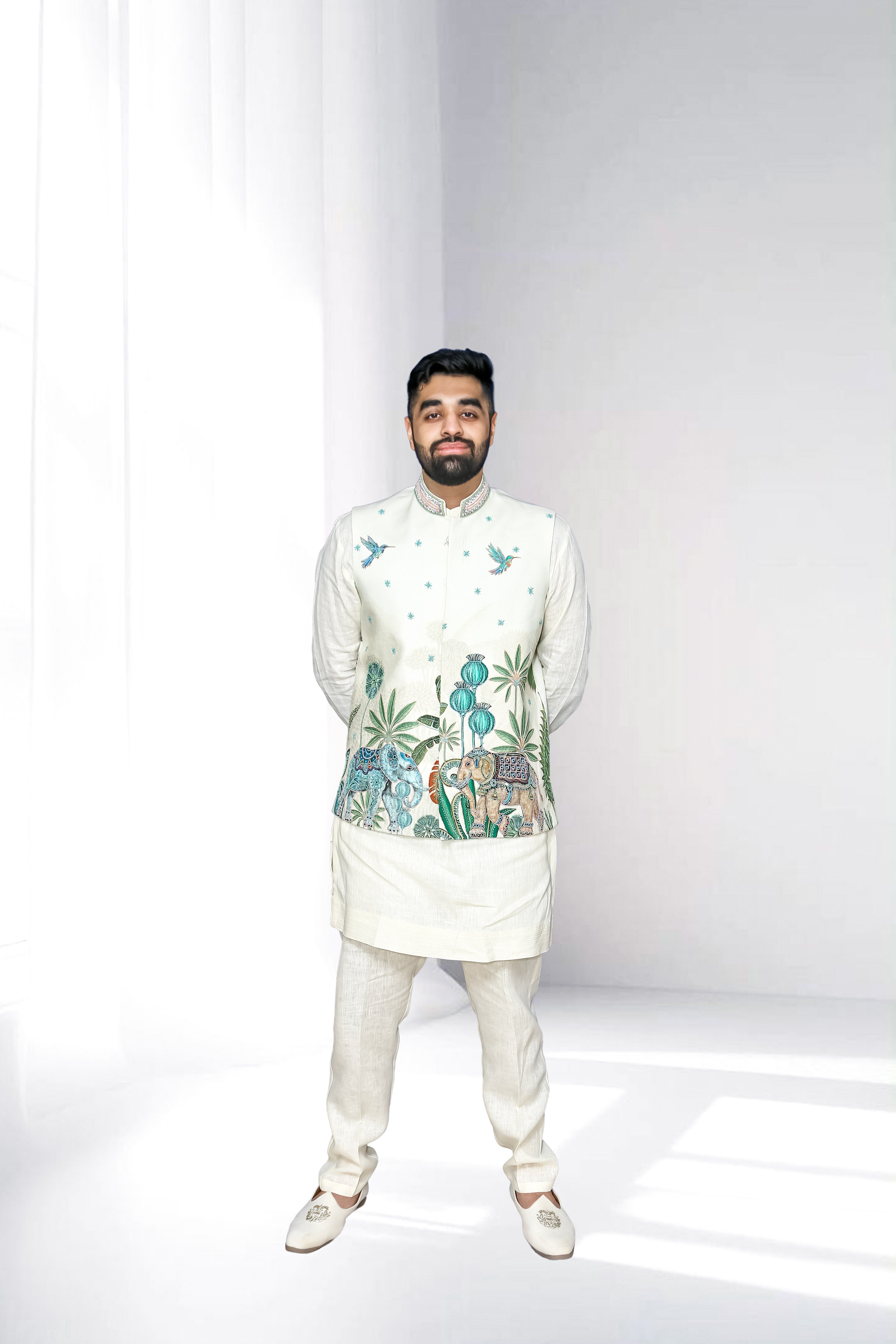 Man wearing a traditional embroidered Kurta Pajama with Nehru Jacket on a white background
