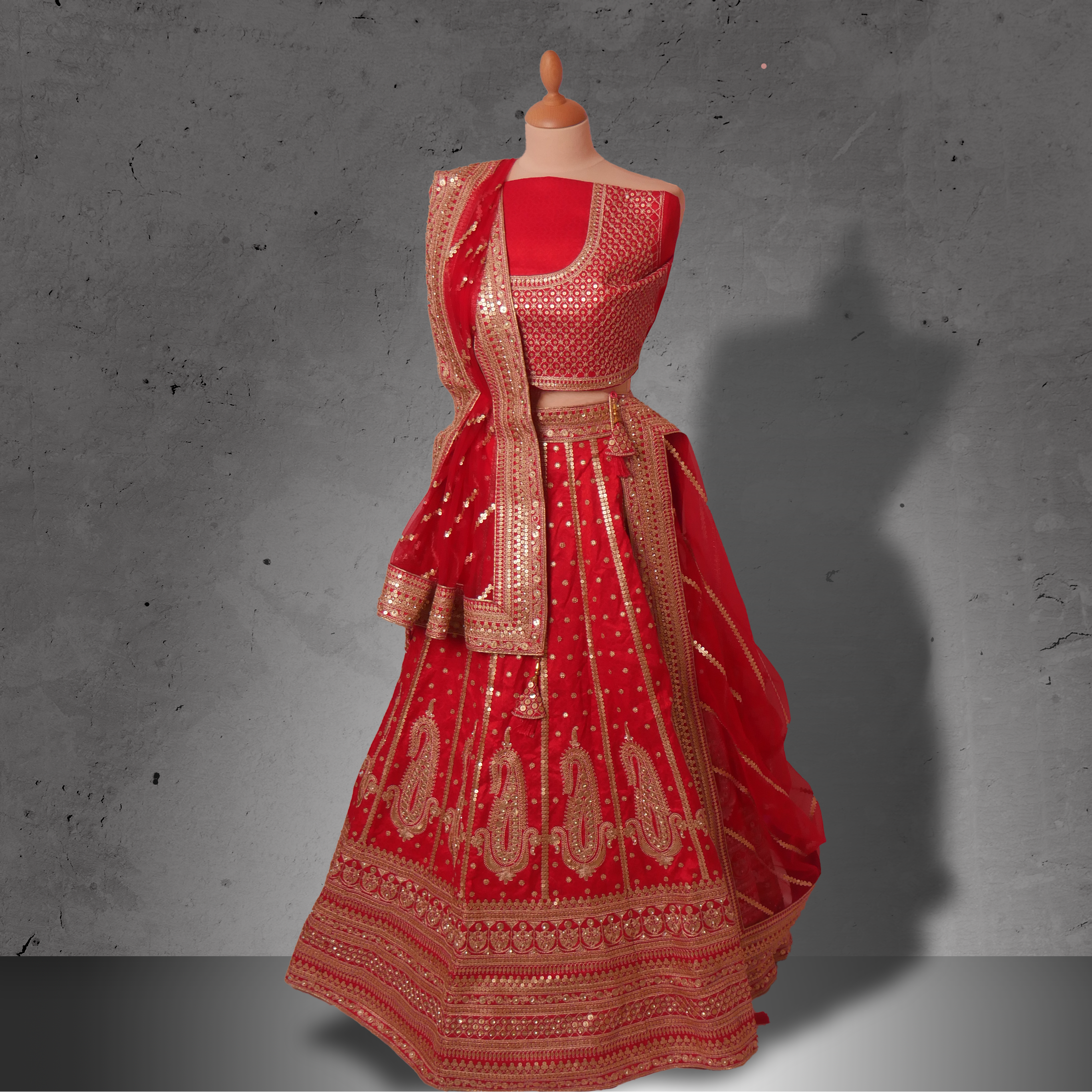 Unstitched red silk bridal lehenga with dense sequin and zari embroidery, paired with a matching net dupatta.