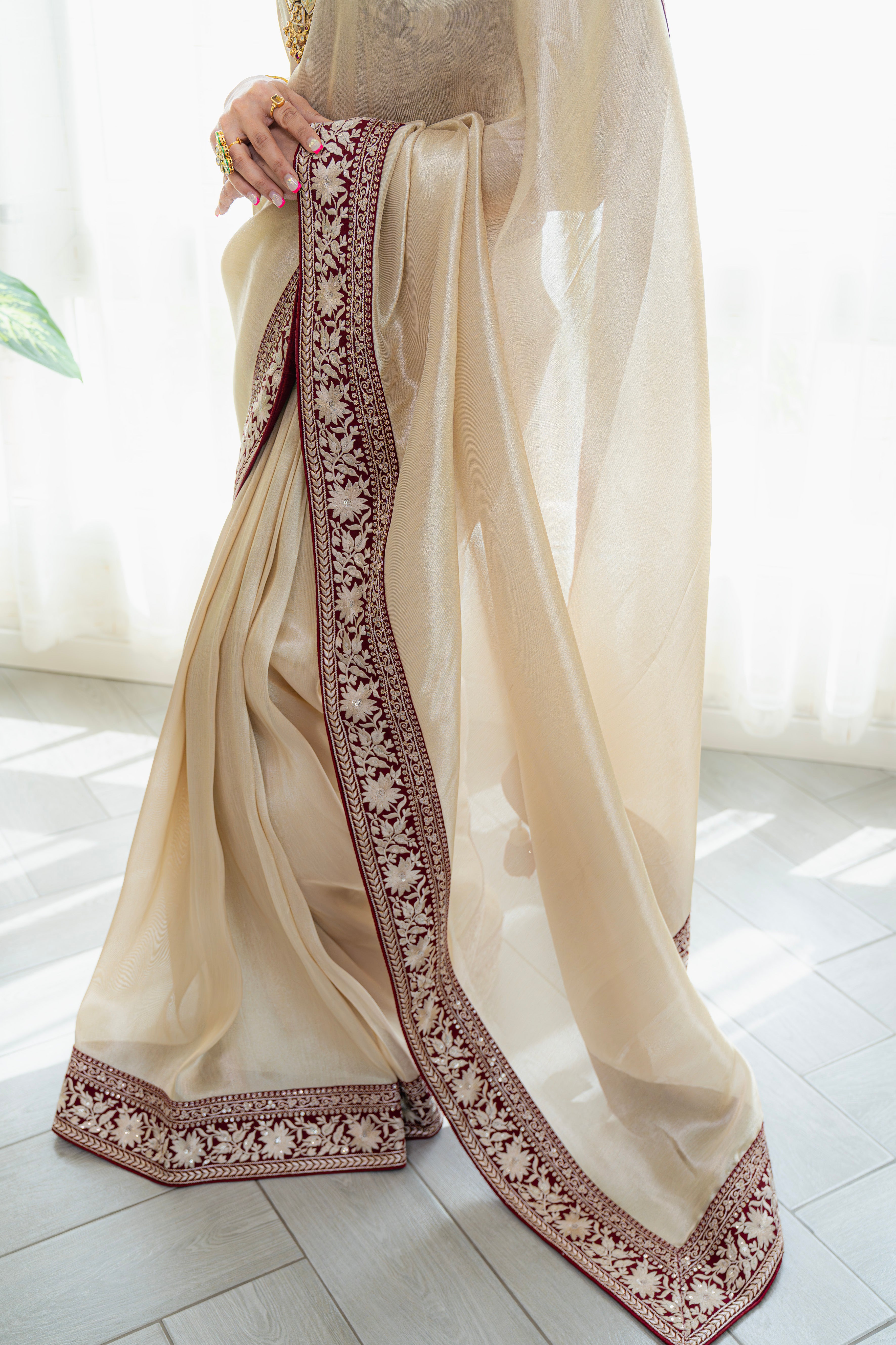 Beige saree with intricate brown embroidery on a light background