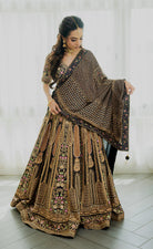 Woman wearing a deep brown embroidered bridal lehenga with floral detailing, styled with a matching dupatta, perfect for weddings and festive occasions.