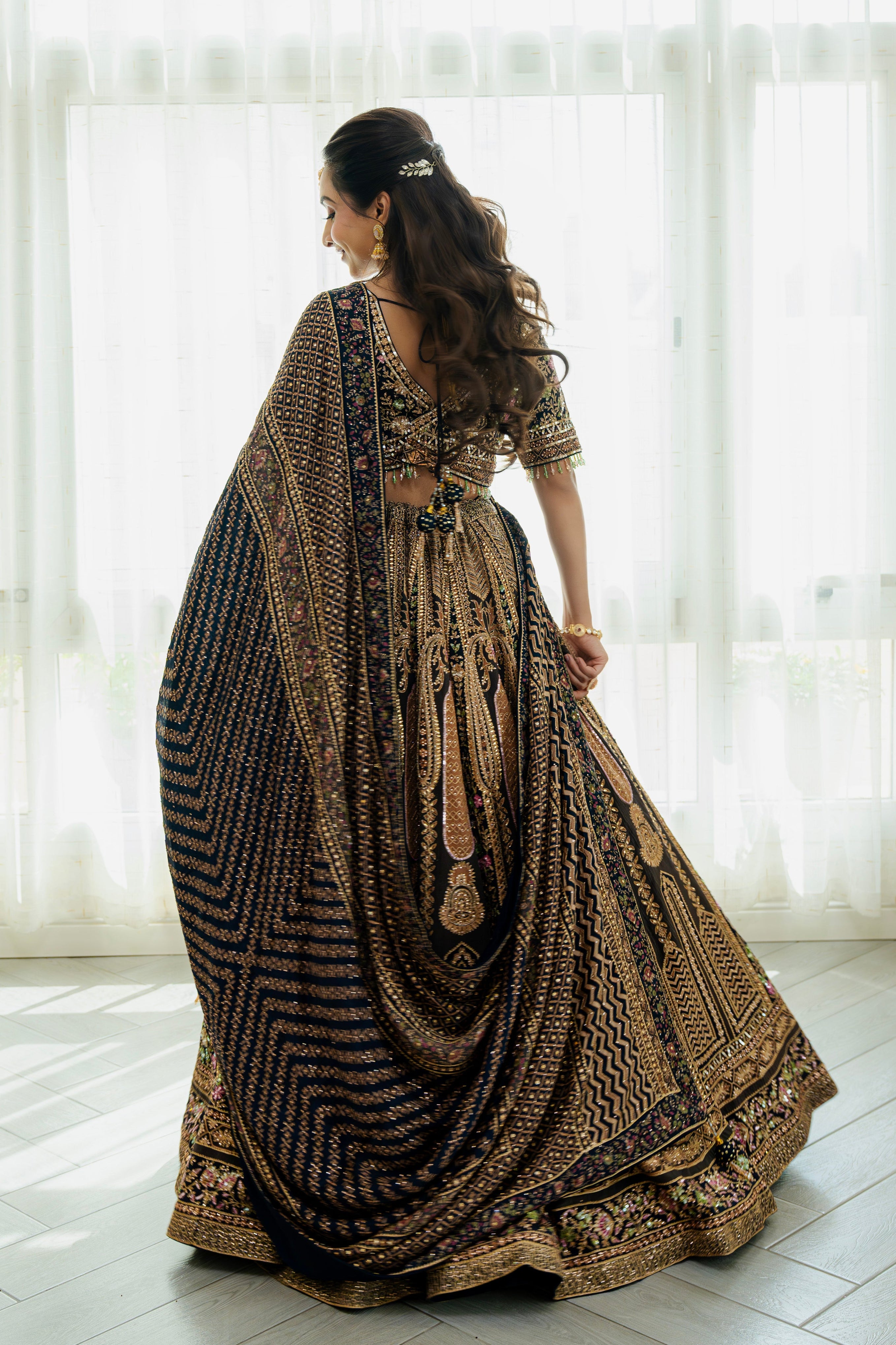 Woman wearing a deep brown embroidered bridal lehenga with floral detailing, styled with a matching dupatta, perfect for weddings and festive occasions.