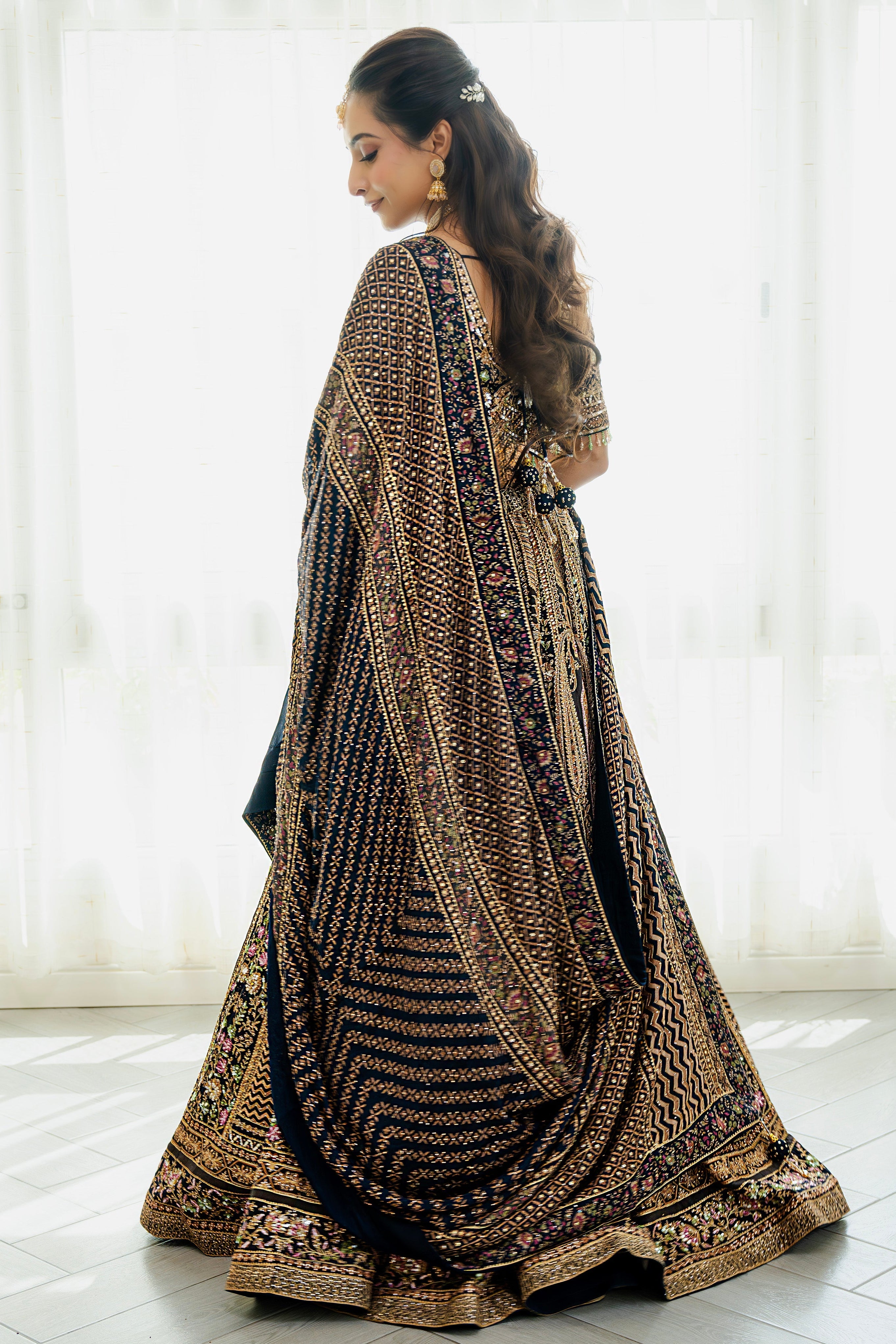 Woman wearing a deep brown embroidered bridal lehenga with floral detailing, styled with a matching dupatta, perfect for weddings and festive occasions.