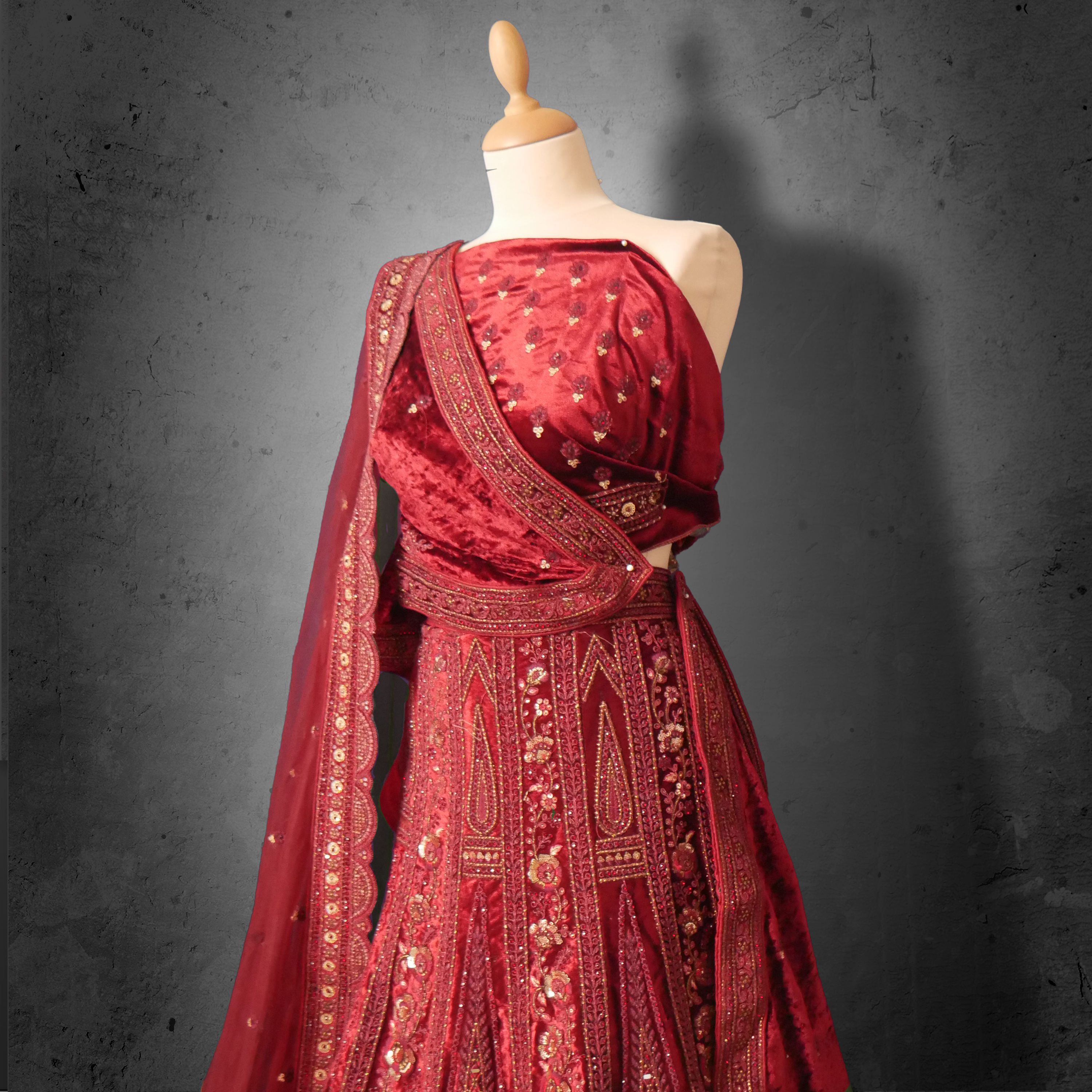 Unstitched red maroon velvet lehenga set with zari, mirror, and sequin embroidery, paired with a matching net dupatta.