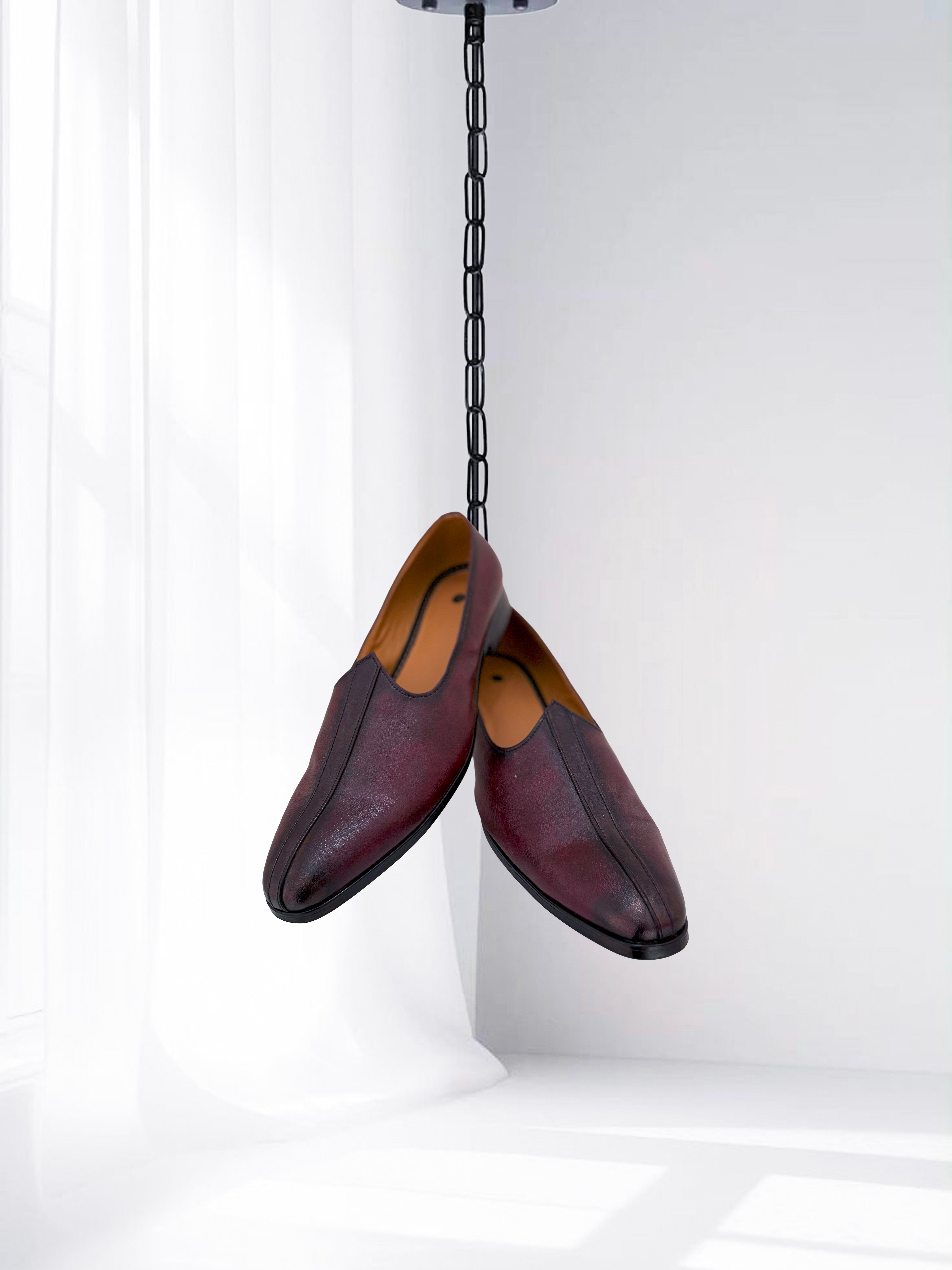 Maroon leather slip-on loafers for men, minimalist formal shoes displayed against a white background