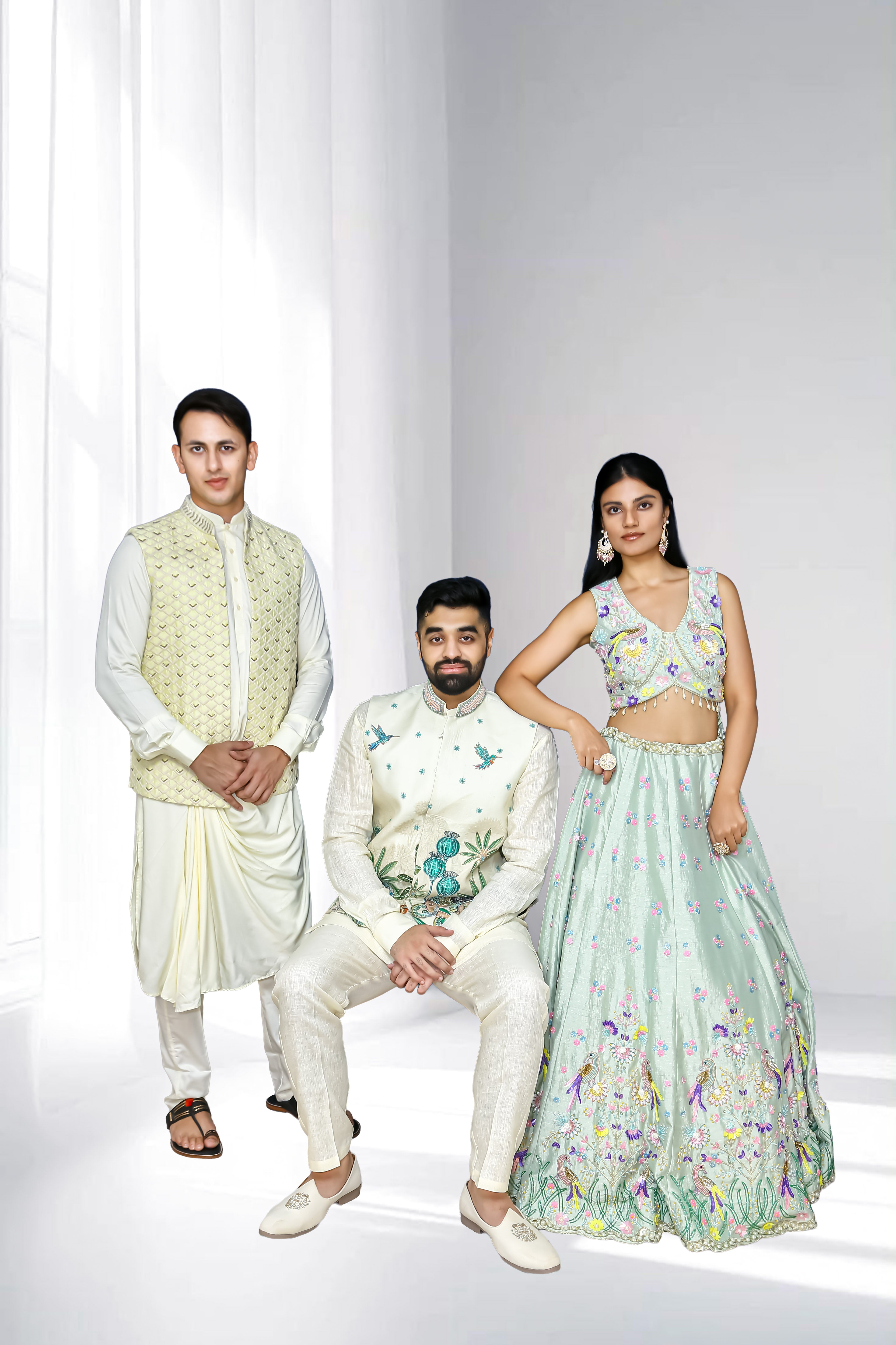 Pastel ethnic wear collection featuring a woman in a mint embroidered lehenga and two men in ivory sherwanis with embroidered details, styled for weddings and festive occasions