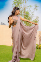 Woman wearing an onion purple ready-to-wear saree styled with a jewelled halter neck pleated blouse, perfect for festive and formal occasions.