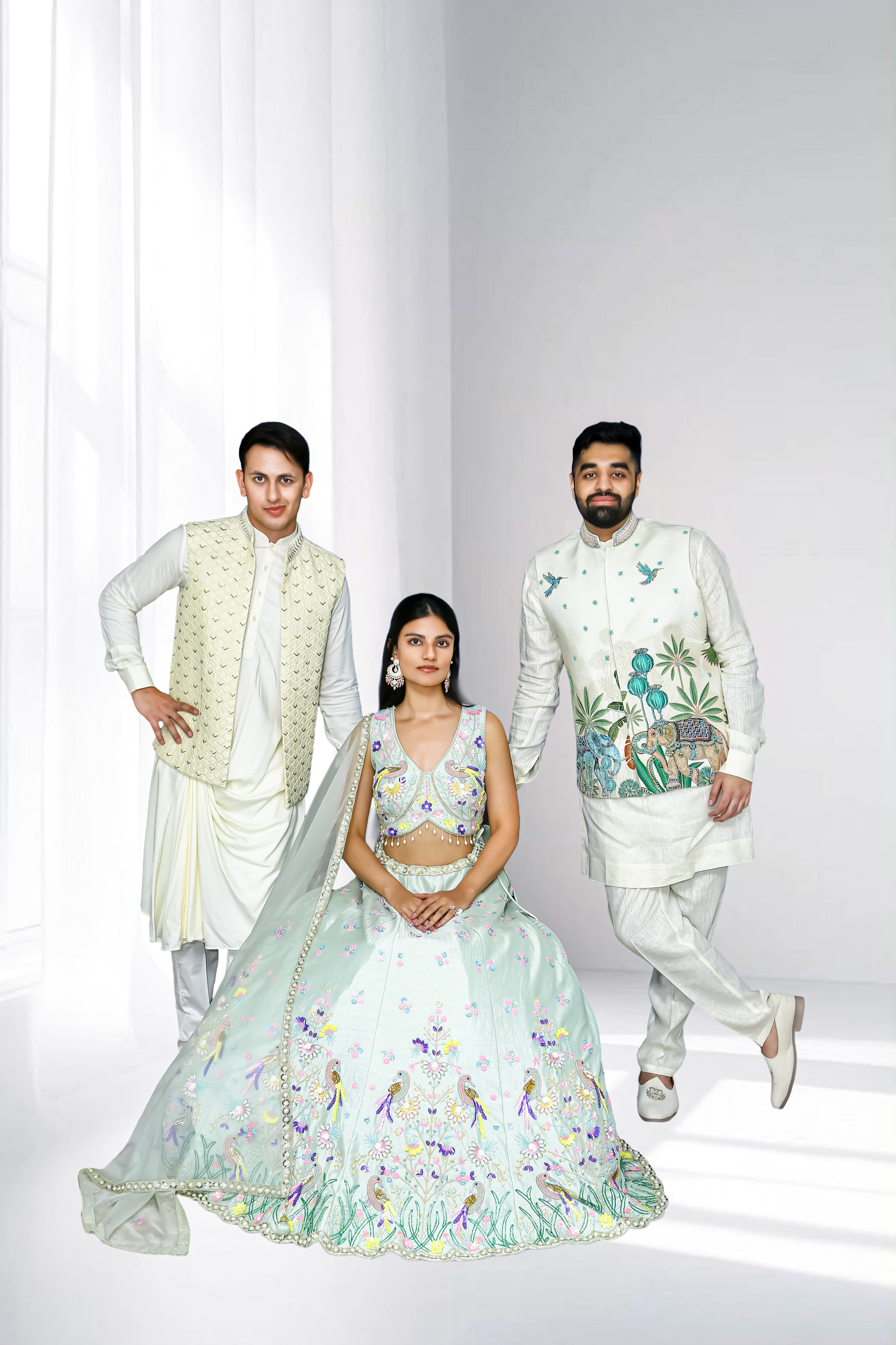 Pastel ethnic wear collection featuring a woman in a mint embroidered lehenga and two men in ivory sherwanis with embroidered details, styled for weddings and festive occasions