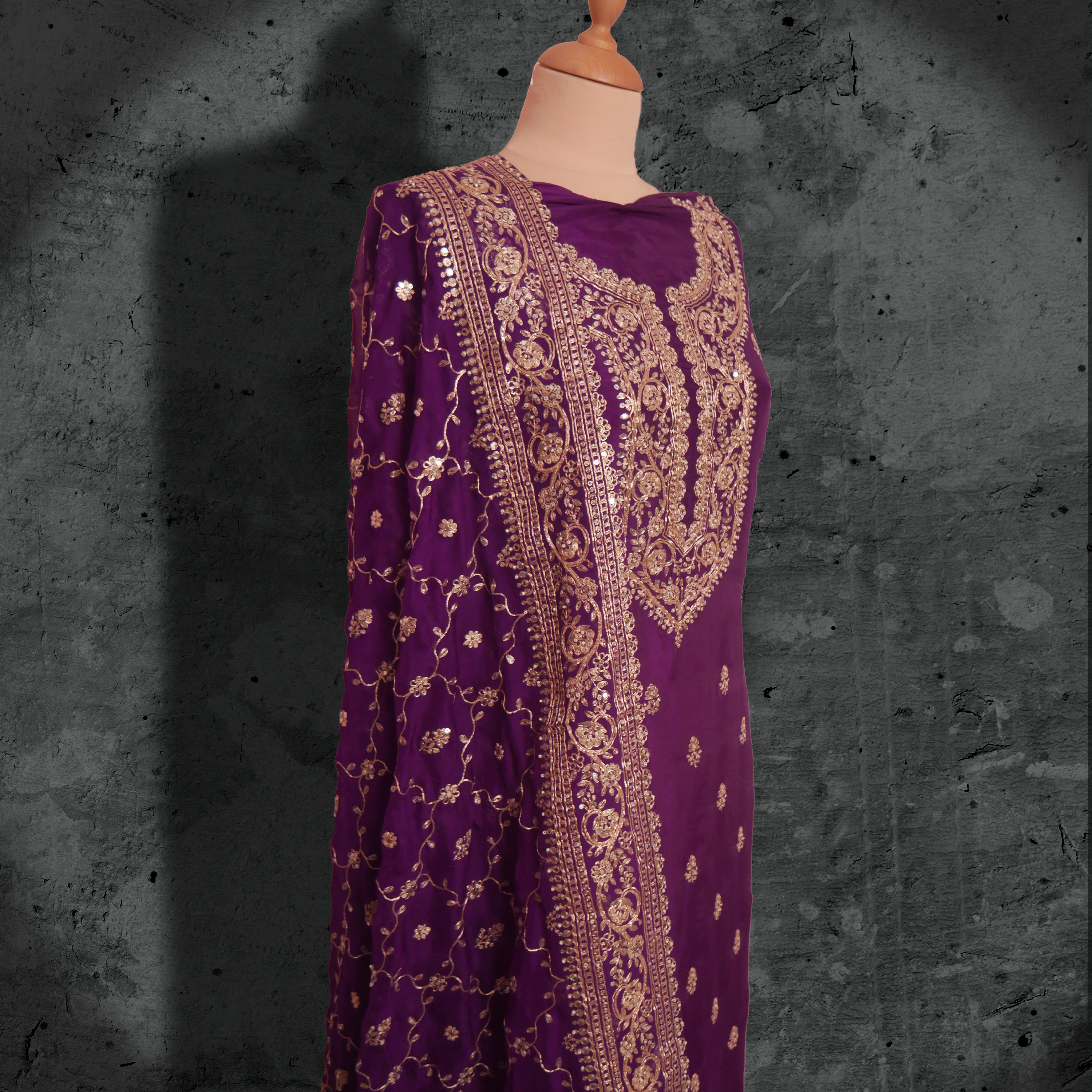 Unstitched plum purple georgette suit with gold zari embroidery and matching embroidered dupatta.