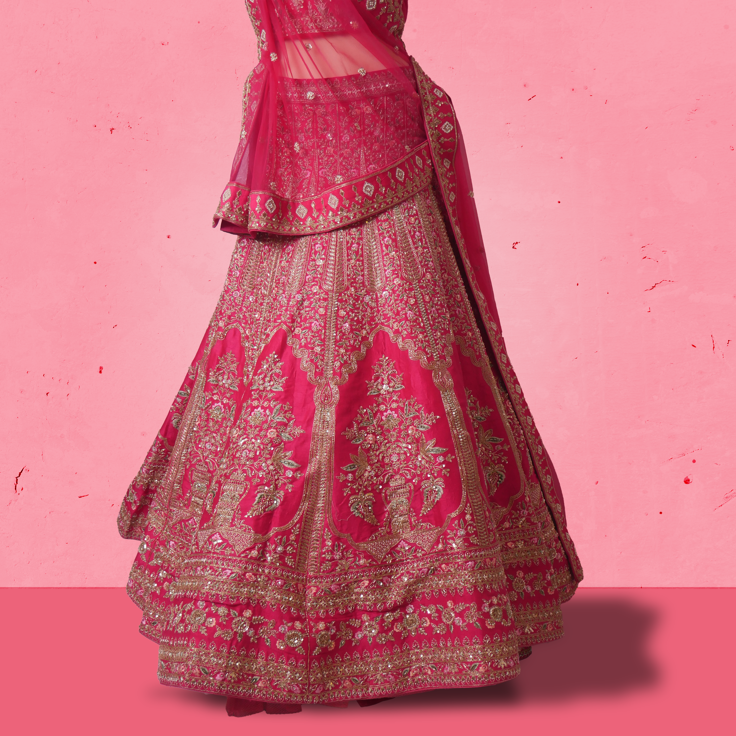 Unstitched rani pink net lehenga set with zari and sequin embroidery, paired with matching embroidered dupatta.