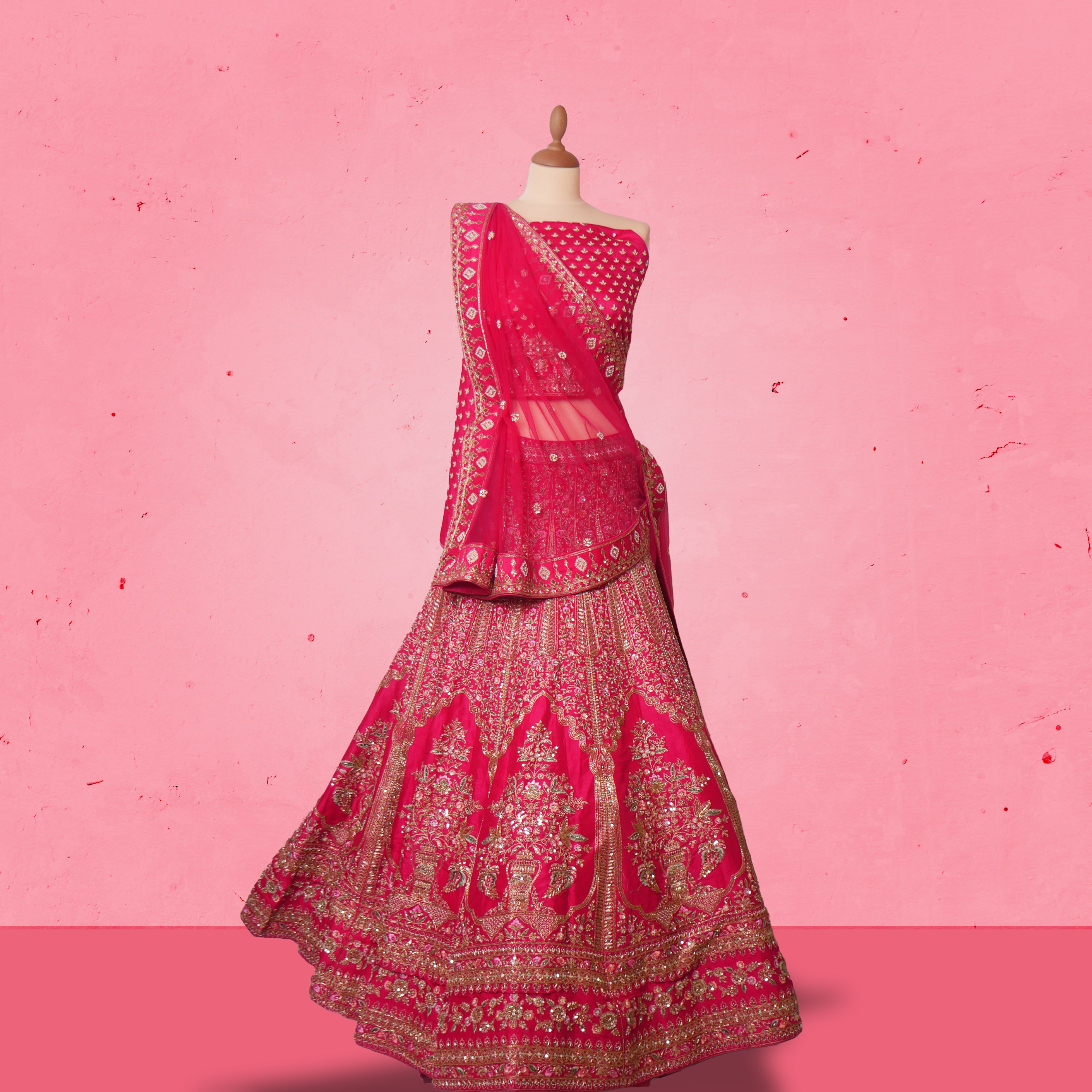 Unstitched rani pink net lehenga set with zari and sequin embroidery, paired with matching embroidered dupatta.