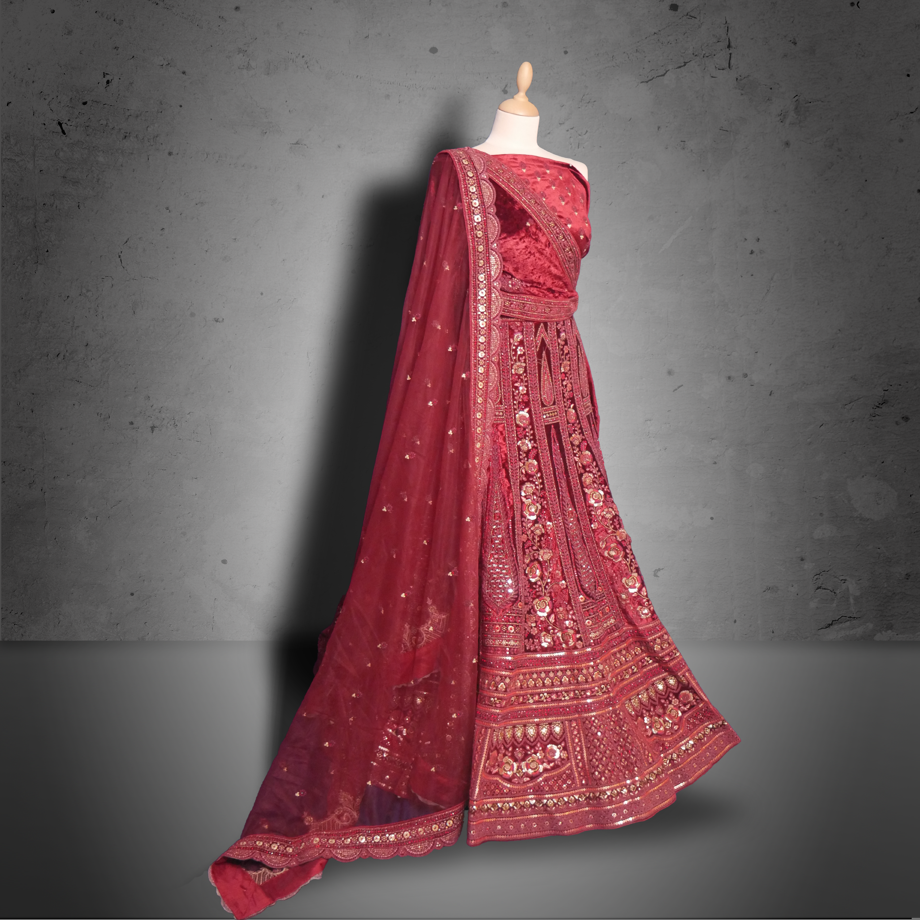 Unstitched red maroon velvet lehenga set with zari, mirror, and sequin embroidery, paired with a matching net dupatta.