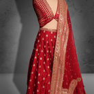 Unstitched red net bridal lehenga with gold zari and sequin embroidery, paired with matching dupatta featuring ornate border.